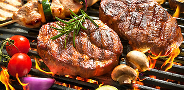 A professional BBQ catering buffet featuring grilled meat, chicken and sausages.